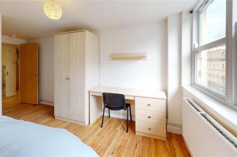 A bright, tidy bedroom with a large window allo...
