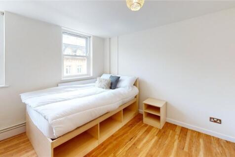 A bright and tidy bedroom featuring a comfortab...