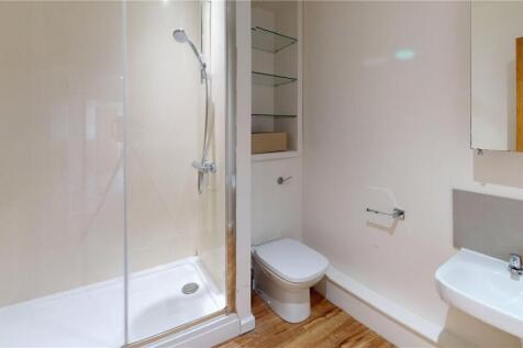 Bright and clean bathroom featuring a glass-enc...