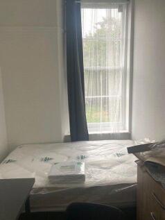 A simple, clean single bedroom with a large win...