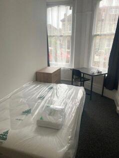 A bright single bedroom with large bay windows ...