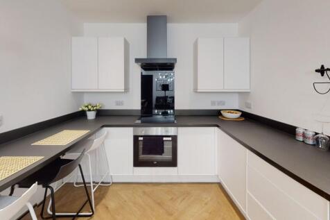 Modern and clean kitchen with white cabinetry, ...