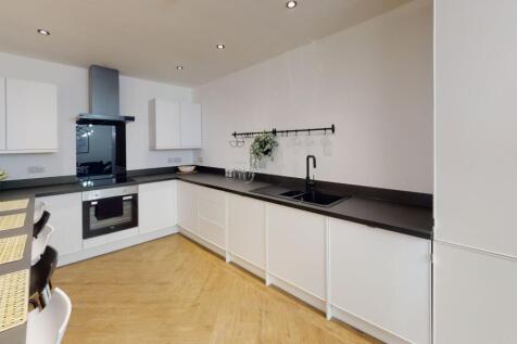 Modern, clean kitchen with white cabinetry, bla...