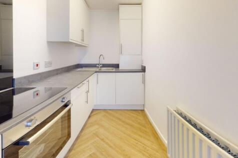 A modern, tidy kitchen with sleek white cabinet...