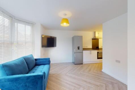 Bright and spacious living room featuring large...