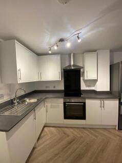 Modern, well-equipped kitchen with white cabine...