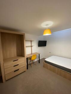 A cozy single bedroom with natural light, featu...