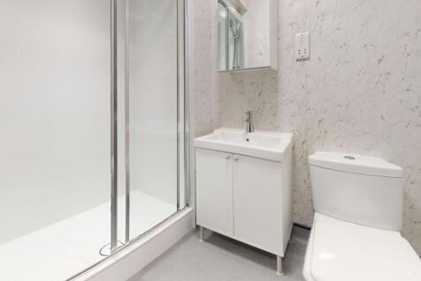 A modern, tidy bathroom featuring a shower encl...