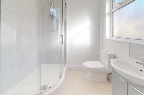 Bright, modern bathroom featuring a glass showe...