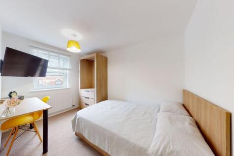 Bright, cozy bedroom featuring a comfortable do...