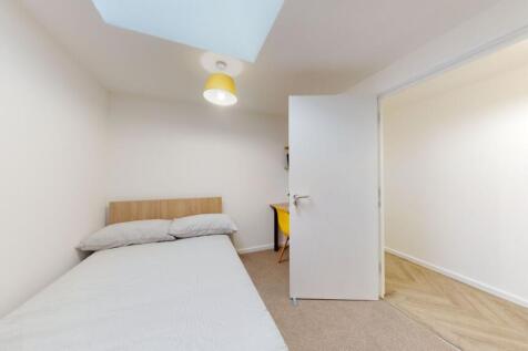 A bright, inviting single bedroom featuring a c...