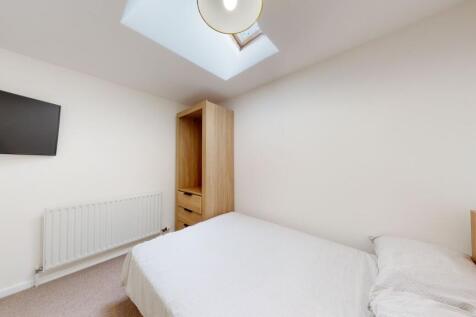 A bright and clean bedroom featuring a comforta...
