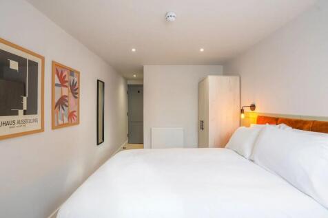 A spacious and bright master bedroom featuring ...