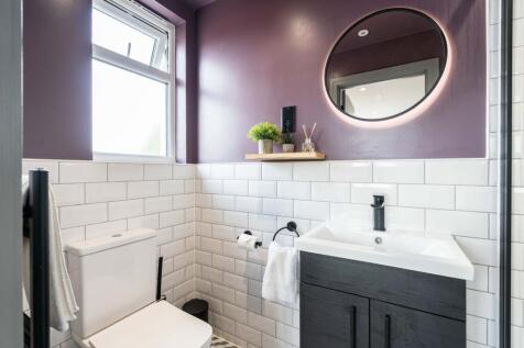 Modern bathroom featuring white tiled walls, a ...
