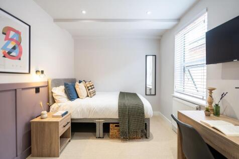 A bright and inviting master bedroom featuring ...