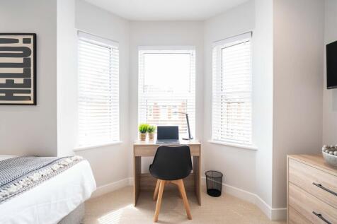Bright and welcoming bedroom featuring a spacio...
