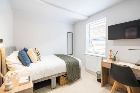 A bright and inviting bedroom featuring a comfo...