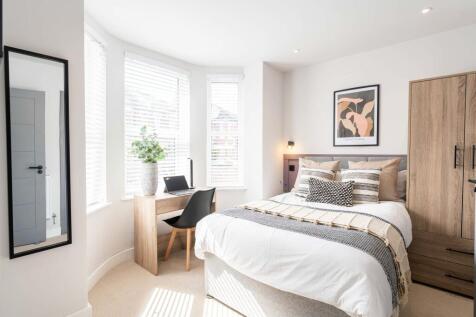 Bright and stylish master bedroom featuring a l...
