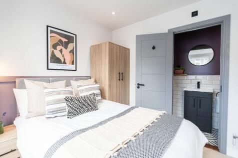 Bright and stylish master bedroom featuring a c...