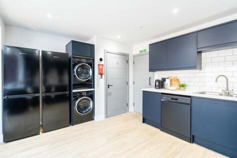Modern kitchen featuring sleek navy blue cabine...