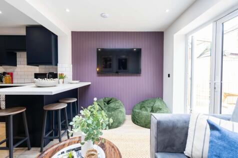 A bright and modern living room featuring large...