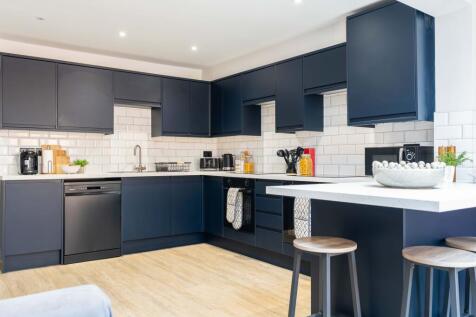 Modern kitchen with sleek navy blue cabinets, w...