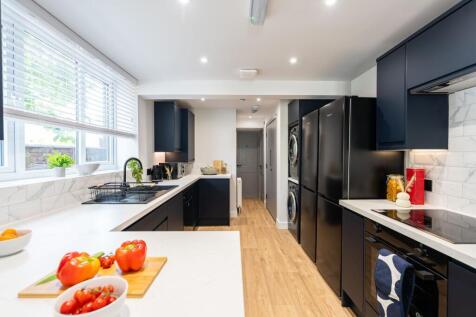 Modern kitchen with sleek navy blue cabinetry, ...