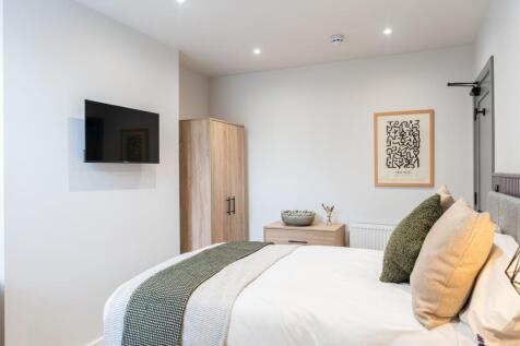 Bright and stylish master bedroom featuring a c...