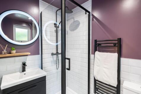 Modern and stylish bathroom featuring a walk-in...