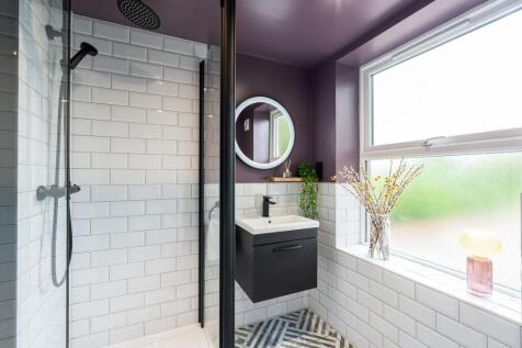Modern bathroom featuring a walk-in shower with...