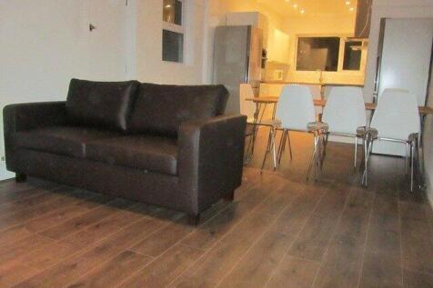 A modern living room with a dark brown sofa and...