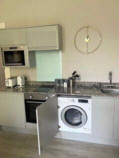 Modern kitchen area featuring integrated applia...