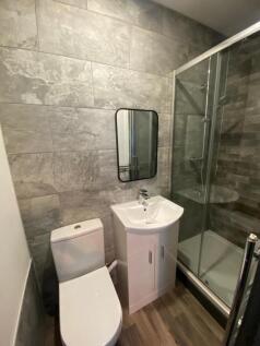 This modern bathroom features sleek gray tiles,...