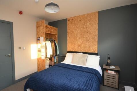 A modern bedroom featuring a neatly made bed wi...