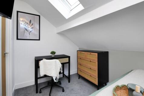A bright and tidy bedroom featuring a modern de...