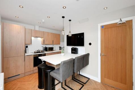 Modern kitchen with sleek wooden cabinetry, a s...