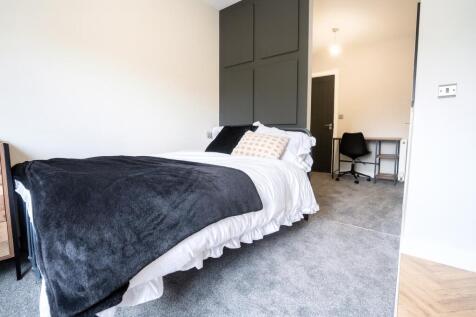 A bright, modern bedroom featuring a comfortabl...