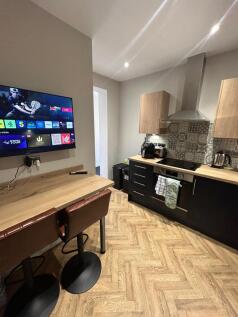Modern kitchen with wooden countertops, a tiled...