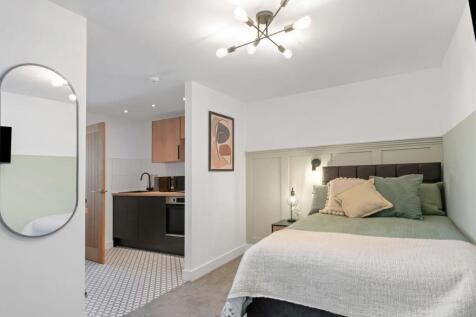 A bright and stylish bedroom featuring a comfor...
