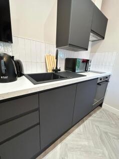 Modern kitchen with sleek dark cabinetry, a bla...