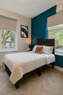 Bright and modern master bedroom featuring a la...