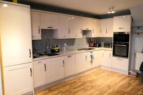 Modern, clean kitchen with white cabinets, ampl...