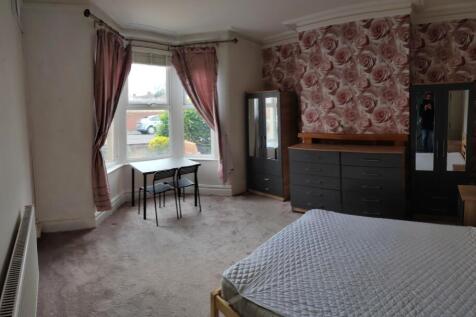 A bright and welcoming bedroom featuring a larg...