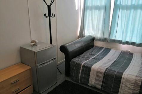 A tidy double bedroom featuring a bed, a small ...