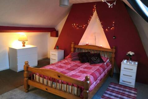 A cozy double bedroom with a wooden bed, decora...