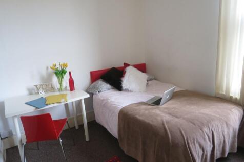 A cozy double bedroom featuring a bed with pill...