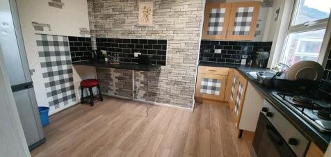A modern kitchen featuring wooden cabinets with...