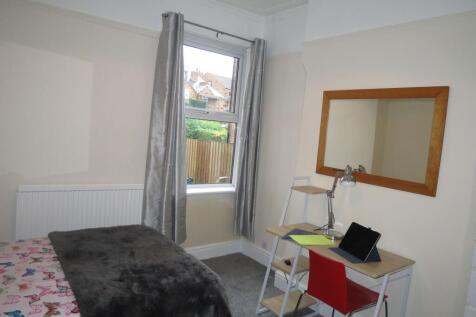 Bright and cozy single bedroom featuring a wind...