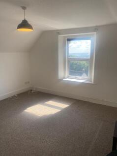 A bright and airy bedroom with a large window o...