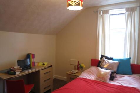 A spacious and well-lit master bedroom with a c...